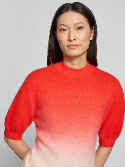 Frauenmodel trägt Strickpullover aus Kaschmir-Baumwoll-Mix mit Puffärmeln von HERZENS in Rot-Verlauf, Regular-Fit, Stehkragen, 1/2-Arm, Nahaufnahme Oberkörper. Rückenlänge bei Größe 36: 56 cm, Ärmellänge bei Größe 36: 26 cm.