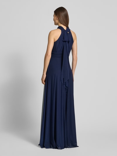 Modelka kobieca ma na sobie ciemnoniebieskie 'Abendkleid mit rückseitiger Schnürung' od TROYDEN COLLECTION z szyfonu, krój slim fit, długość maxi, dekolt halter z dziurką, sznurowanie z tyłu, długość pleców w rozmiarze 36: 159 cm, szerokość w rozmiarze 36: 36 cm, widok całopostaciowy z tyłu.