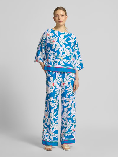 Frauenmodel trägt Relaxed Fit Bluse aus reiner Viskose Modell 'Rylie' von GUIDO MARIA KRETSCHMER WOMAN mit blau-weißem floralen Allover-Print, 3/4-Arm, glatte Textur, Rückenlänge 55 cm bei Größe 36, Ganzkörperansicht von vorne.