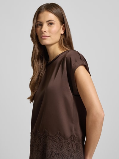 Frauenmodel trägt T-Shirt mit Rundhalsausschnitt Modell 'ELLETTE' von Vila, Satin mit Spitzenbesatz, lockerer Schnitt, Nahaufnahme Oberkörper.