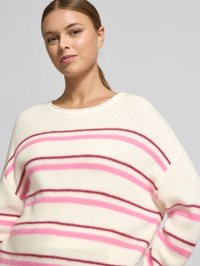 Modelka kobieca ma na sobie Regular Fit Pullover aus Alpaka-Mix mit Kaschmir-Anteil od Marc Cain, kremowy sweter w różowe i brązowe paski, dzianinowa faktura, okrągły dekolt, elastyczne wykończenia, długość tyłu w rozmiarze 36: 56 cm, długość rękawa w rozmiarze 36: 51 cm, widok z przodu, zbliżenie na górną część ciała.