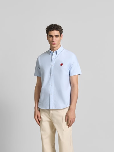 Männermodel trägt Slim Fit Freizeithemd mit Logo-Stitching von Kenzo in Hellblau aus Reine Baumwolle, Button-Down-Kragen, Kurzarm, Ganzkörperansicht von vorne.