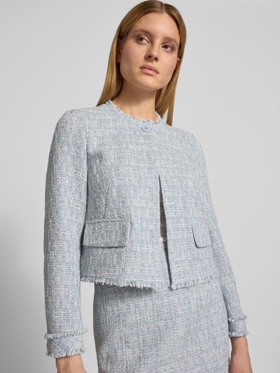 Frauenmodel trägt Regular Fit Blazer in Bouclé-Optik von Marc Cain aus Baumwoll-Mix mit Pattentaschen, Rundhalsausschnitt, Nahaufnahme Oberkörper.