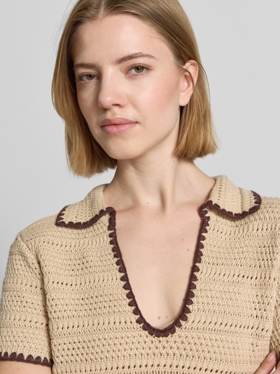 Frauenmodel trägt T-Shirt in Strick-Optik mit Polokragen und Kontrastkante von Stefanel in Beige mit braunen Abschlüssen, reine Baumwolle, Nahaufnahme Oberkörper.