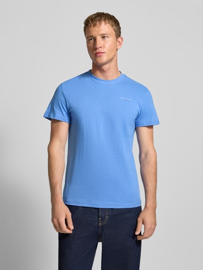 Männermodel trägt Slim Fit T-Shirt aus reiner Baumwolle von Tommy Jeans, Optik: Unifarben, Label-Print, Rundhals, Kurzarm, Ganzkörperansicht von vorne.