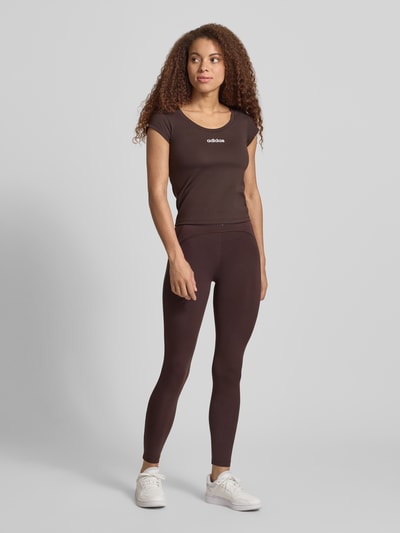 Vrouwenmodel draagt Slim Fit Sport T-Shirt met Label Print van adidas Sportswear, effen, slim fit, ronde hals, korte mouwen, stretchstructuur, full-body vooraanzicht.