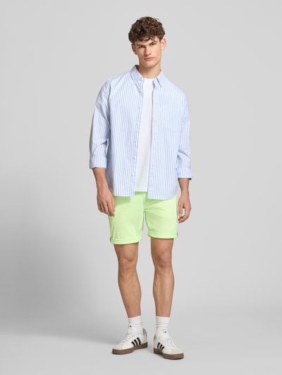 Männermodel trägt Regular Fit Shorts mit Münztasche von Superdry in hellem Grün, Baumwoll-Mix, mit Gesäßtaschen, Ganzkörperansicht von vorne.