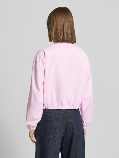 Frauenmodel trägt Relaxed Fit Blouson mit Taillenbändern von Tommy Jeans in Hellrosa, unifarben, elastischer Ärmelabschluss, Rückansicht, Ganzkörperansicht Rückansicht.