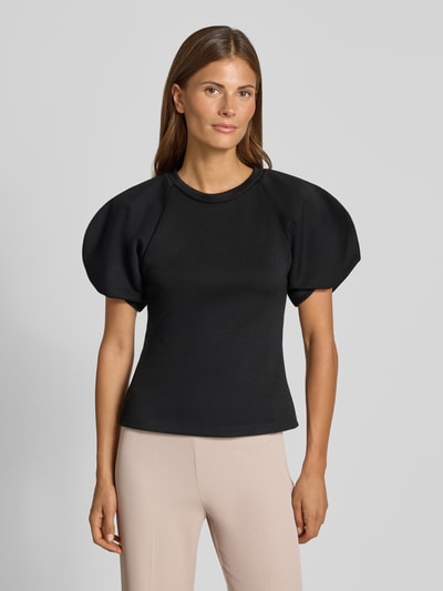 Vrouwenmodel draagt blouse met ballonmouwen van Rinascimento in zwart, Materiaalmix met stretch, getailleerde pasvorm, ronde hals, ruglengte maat S 55 cm, mouwlengte maat S 27 cm. Ganzichaanszicht van voren.