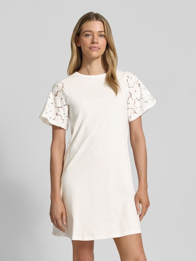 Frauenmodel trägt Leicht ausgestelltes Freizeitkleid aus reiner Baumwolle Modell 'VILLA' von Vero Moda, Optik: Unifarben, Mini-Länge, Rundhals, Spitzenbesatz, Ärmelform: Kurzarm, Saum: Gerade, Materialverarbeitung: Jersey, Ganzkörperansicht von vorne.