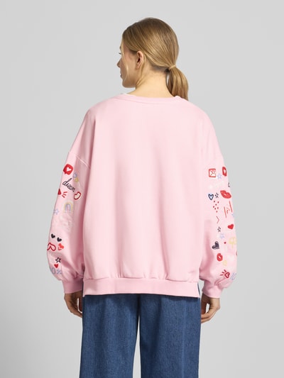 Vrouwenmodel draagt Oversized Fit Sweatshirt met v-hals van Smith and Soul in lichtroze, mix van katoen en modal, elastische boorden, geheel van achteren