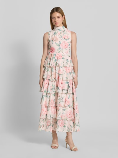 Vrouwenmodel draagt vrijetijdsjurk met gebloemd motief, getailleerd model 'FELICIA' van Vero Moda in kleurrijke chiffon, midilengte, hooggesloten hals, met volants, look: meerkleurig. Ganzkörperansicht van voren.