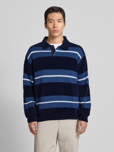 Männermodel trägt Regular Fit Pullover aus Baumwoll-Mix Modell 'AMBURGH' von BOSS Orange, gestreift, mehrfarbig, Strickoptik, Ganzkörperansicht von vorne.