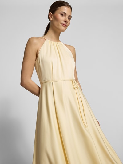 Vrouwenmodel draagt Cocktailkleid aus Satin mit Bindegürtel van Jake*s Cocktail, lichtgeel satijn, a-lijn, halternek, riem, borstwijdte 40 cm, ruglengte 130 cm, close-up bovenlichaam.