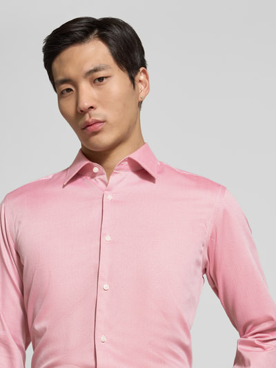 Männermodel trägt Regular Fit vrijetijdsoverhemd uit katoenmix model 'H-JOE-K-C1-261' van BOSS, all-over motief, kentkraag, doorlopende knoopsluiting, geruit patroon, labelstitching, achterpas, lange mouwen met verstelbare manchet, licht afgeronde rompzoom, popeline materiaal. Nahaufnahme bovenlichaam, vooraanzicht.