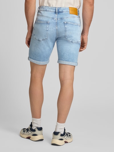 Męski model nosi Regular Fit Jeansshorts aus Baumwoll-Mix Modell '' von Only & Sons, jasnoniebieski denim, 5 kieszeni, naszywka z logo, widok całej sylwetki z tyłu.