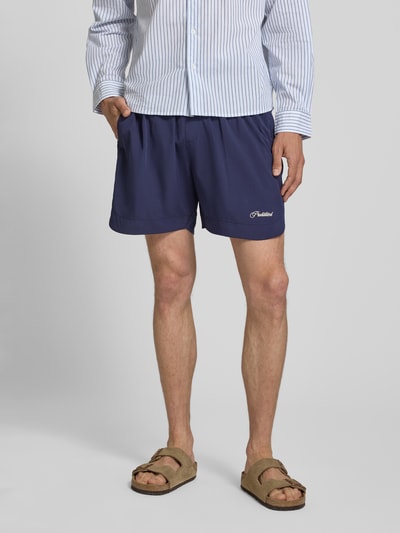 Männermodel trägt Badehose mit Label-Stitching und elastischem Bund von PROHIBITED, Regular-Fit, navy, Ganzkörperansicht von vorne.