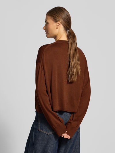 Vrouwenmodel draagt gebreide pullover uit zuivere scheerwol Model 'MALESE' van DRYKORN, relaxed fit, ronde hals, ruglengte 49 cm, mouwlengte 52 cm, donkerbruin, glad textuur, rechte lijnen, Ganzkörperansicht Rückansicht