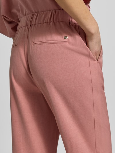 Frauenmodel trägt Hose aus Viskose-Mix Modell 'Bai Roy' von MOS MOSH in Rosa, glatte Struktur, mit Gesäßtaschen, Detailaufnahme Rückansicht. Damenhose mit Stretchanteil, Slim Fit, elastischer Bund, gemäß Größenangaben.