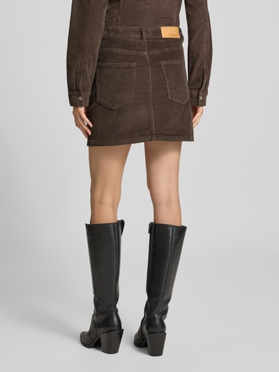 Frauenmodel trägt Minirock aus Baumwoll-Mix in Cord-Optik Modell 'Yolanda' von NOISY MAY®, braun, 5-Pocket-Design, Ganzkörperansicht Rückansicht.
