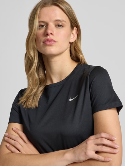 Frauenmodel trägt Damen T-Shirt mit Logo Modell 'Tempo' von NIKE TRAINING, Regular-Fit, Rundhalsausschnitt, schwarze Farbe, Nahaufnahme Oberkörper.