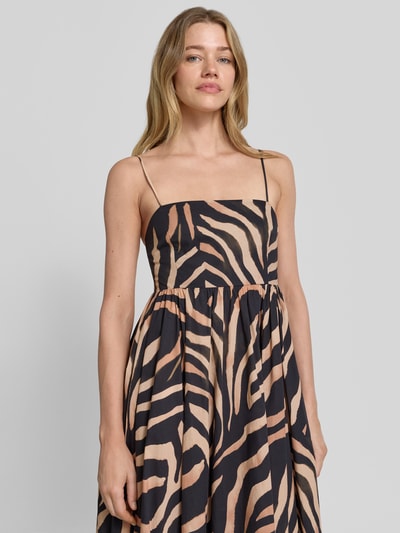 Frauenmodel trägt Empire Trägerkleid aus reiner Baumwolle Modell 'KUMARE-1' von HUGO mit Optik: Allover-Muster Animal-Print, Materialverarbeitung: Popeline, Farbe Beige und Schwarz, Maxi-Länge, Henley-Ausschnitt, Nahaufnahme Oberkörper.