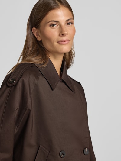Kobiece modelka nosi ciemnobrązowy trencz Loose Fit Trenchcoat aus Lyocell-Mix model 'Haweni' od OPUS, gładka faktura, zbliżenie na górę ciała