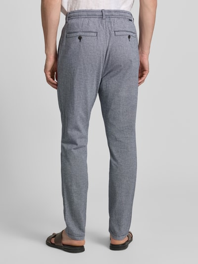 Mężczyznamodel nosi Regular Fit Chino aus Baumwoll-Mix od Tom Tailor, melanż, bawełniany mix, pasujące prosto, z szlufkami, kieszeniami z tyłu i po bokach, z guzikiem i ukrytym zamkiem, widoczny label patch, widok całej sylwetki od tyłu.
