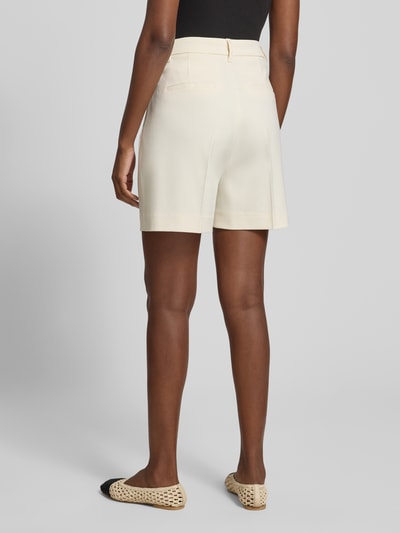 Männermodel trägt Straight Fit Shorts mit Viskose-Anteil Modell 'Tailor' von Copenhagen Muse, elastyczna mieszanka materiałów z dodatkiem wiskozy, krój straight fit, zakładki w pasie, wpuszczane kieszenie, zapięcie na haftkę i zamek błyskawiczny, szerokość w rozmiarze S: 37 cm, długość wewnętrzna nogawki: 11 cm, kremowy kolor, gładka tekstura, Ganzkörperansicht Rückansicht.
