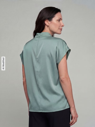 Frauenmodel trägt Blusenshirt mit Stehkragen von Jake*s Collection, mintgrün, glatte Textur, Material-Mix mit Stretch, Ganzkörperansicht Rückansicht.