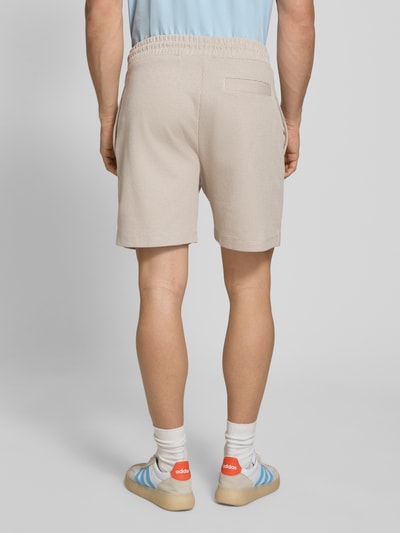 Männermodel trägt Regular Fit Sweatshorts aus Baumwoll-Mix Modell 'NUWAFFLO' von HUGO, Optik: Unifarben, Ganzkörperansicht Rückansicht.
