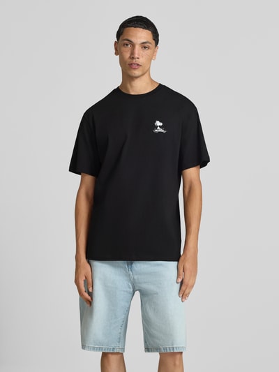 Mannenmodel draagt oversized t-shirt uit pure katoen model 'PEANUTS' van ONLY, zwart, klein peanuts©-motief op de borst, heren t-shirt van ONLY & SONS, volledige vooraanzicht.