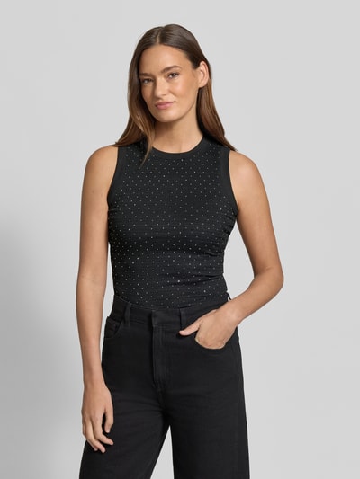 Frauenmodel trägt Top mit Ziersteinbesatz und Rundhalsausschnitt von Guess, Slim Fit, schwarzer Stoff, Modell 'FRANCINE', Nahaufnahme Oberkörper.