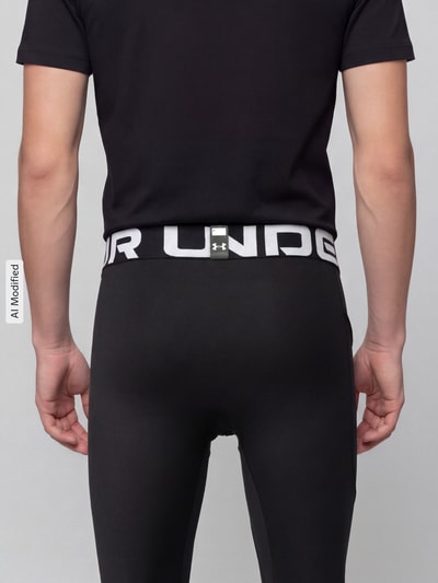 Männermodel trägt schwarze Slim Fit Sport-Leggings mit Logo-Print von Under Armour, glatte Textur, Ganzkörperansicht Rückansicht, KI-modifiziertes Bild.