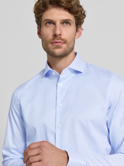 Männermodel trägt Slim Fit Businesshemd mit extra langem Arm von Jake*s, feines Hellblau mit weißen Streifen, Nahaufnahme Oberkörper.