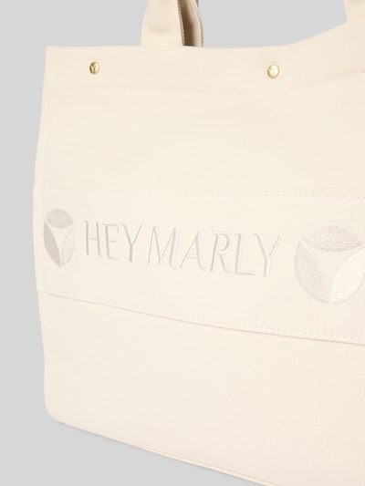 Produktfoto, cremefarbene Handtasche mit Logo-Stitching Modell 'Signature' von Hey Marly, Strukturstoff, goldene Details, Kontext: Damen Handtasche mit Hauptfach, Druckknopfverschluss, Schulterriemen, Reißverschlussfach, Breite 42 cm, Länge 31 cm, Tiefe 15 cm, Länge Schulterriemen 55 cm.