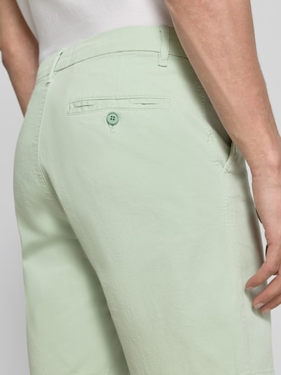 Männermodel trägt Regular Fit Chinoshorts aus Baumwoll-Mix Modell 'CHINO' von Armedangels, Optik: Unifarben, Nahaufnahme Rückansicht.