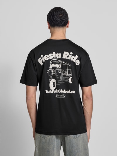 Männermodel trägt Relaxed Fit T-Shirt aus reiner Bio-Baumwolle Modell 'FRED' von Only & Sons in Schwarz mit Rücken-Print, Ganzkörperansicht Rückansicht.