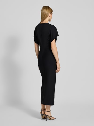 Vrouwenmodel draagt zwart figurbetont Maxi-jurk met V-hals Model 'PAMANTI' van Drykorn, Lyocellmix met stretch, nauw aansluitend model, ruglengte maat S 136 cm, borstwijdte 36 cm, mouwlengte 17 cm, geheel van achteren