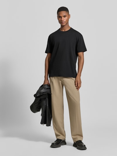 Männermodel trägt Relaxed Fit T-Shirt aus reiner Baumwolle von Marc O'Polo in Schwarz, unifarben, Rundhals, Kurzarm, Feinripp, Ganzkörperansicht von vorne