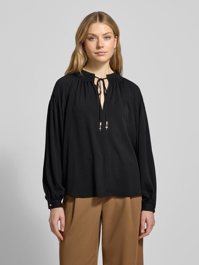 Frauenmodel trägt Blusenshirt mit marszczeniami Modell 'Brigida' von JOOP!, luźny krój, wycięcie w kształcie łezki, czarny, Ganzkörperansicht von vorne.