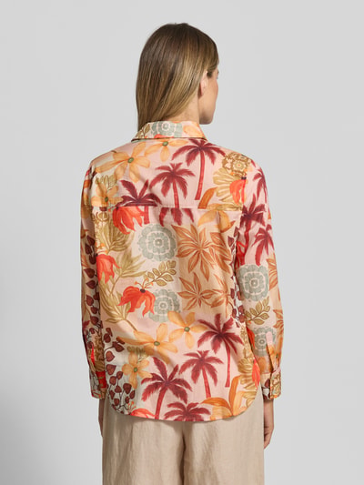 Frauenmodel trägt Regular Fit Bluse im Allover-Look von Christian Berg Woman aus Reine Baumwolle mit Hemdblusenkragen, Rückenlänge 71 cm, Ärmellänge 59 cm, Blumen- und Palmenmuster in Beige, Orange und Rottönen, fließende Struktur, Ganzkörperansicht Rückansicht.