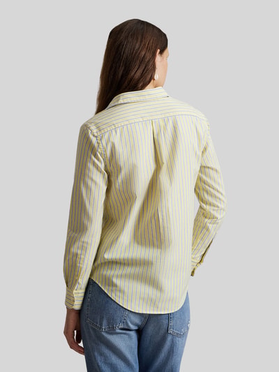 Frauenmodel trägt Regular Fit Hemdbluse aus reiner Baumwolle von Polo Ralph Lauren mit gelb-blauem Allover-Streifenmuster, Ganzkörperansicht Rückansicht.