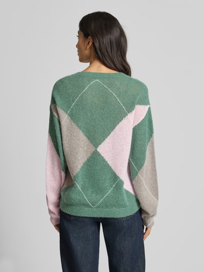 Frauenmodel trägt Wollpullover mit gerippten Abschlüssen von Fynch-Hatton im Material-Mix mit Woll-Anteil, Oversize-Schnitt, Rückenlänge 59 cm, V-Ausschnitt, Farben grün, rosa und beige, weiche und flauschige Textur, Ganzkörperansicht Rückansicht.
