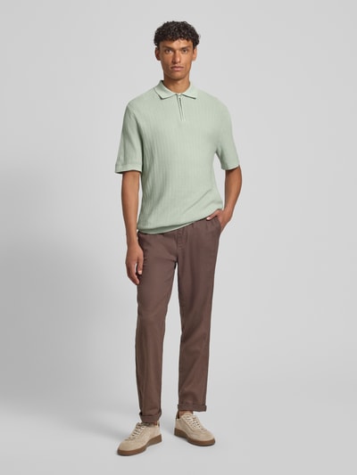 Männermodel trägt Regular Fit Poloshirt aus reiner Bio-Baumwolle Modell 'CRAN' von SELECTED HOMME in Strickoptik, Ganzkörperansicht von vorne.