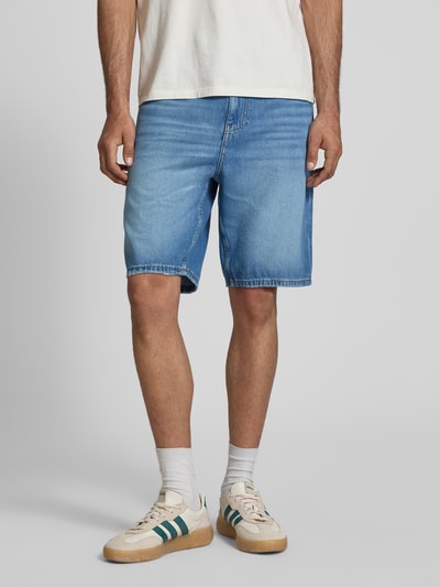 Mężczyznamodel nosi Relaxed Fit Jeansbermuda aus reiner Baumwolle von Tommy Jeans, jasnoniebieski denim, 5 kieszeni, logo-stitching, materiał bawełna, krój relaxed fit, widok całej sylwetki z przodu.
