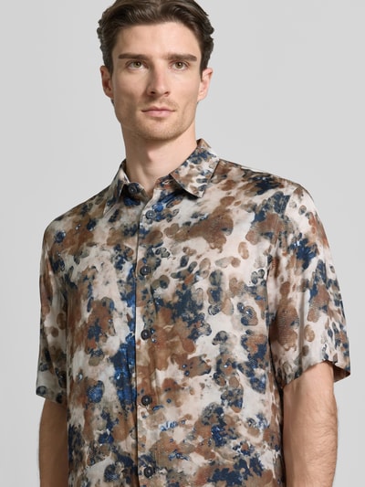 Męski model nosi Boxy Fit Freizeithemd aus Viskose im Allover-Look von ARMANI EXCHANGE, krój boxy fit, czysta wiskoza, wzór allover, kołnierz kent, zapięcie na guziki, długość tyłu w rozmiarze M: 77 cm, szerokość w rozmiarze M: 49 cm, długość rękawa w rozmiarze M: 31 cm, odcienie brązu, beżu i granatu, gładka tekstura; zbliżenie na górną część ciała z przodu