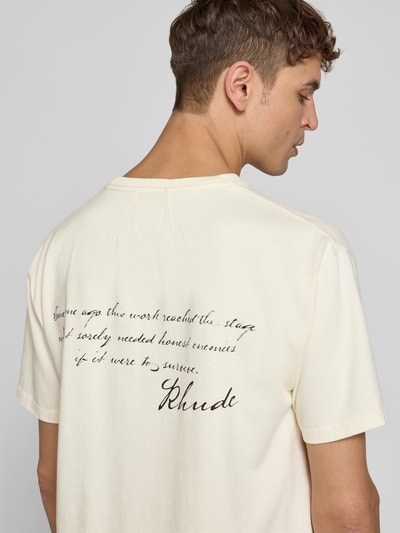 Männermodel trägt Regular Fit T-Shirt mit Motiv-Print von RHUDE aus reiner Baumwolle, helle Farbe, Rückenlänge 66 cm, Ganzkörperansicht Rückansicht.