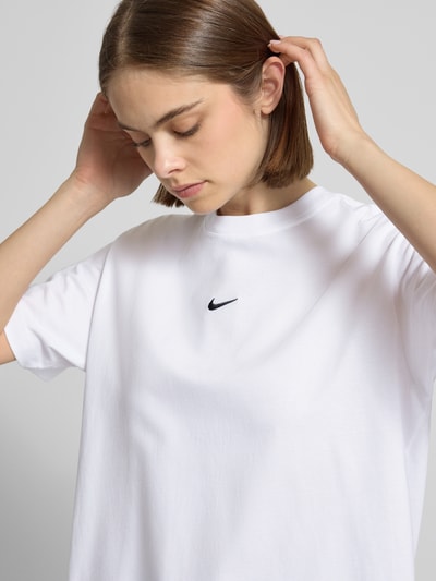 Frauenmodel trägt T-Shirt mit Logo und Rundhalsausschnitt von Nike aus reiner Baumwolle im Relaxed Fit, Nahaufnahme Oberkörper.