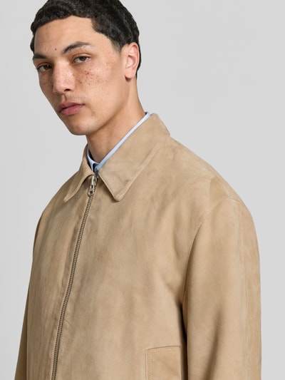 Männermodel trägt Regular Fit Jacke aus echtem Ziegenleder von ANNARR in Beige mit Umlegekragen, Eingrifftaschen, Zweiwege-Reißverschluss, Nahaufnahme Oberkörper.